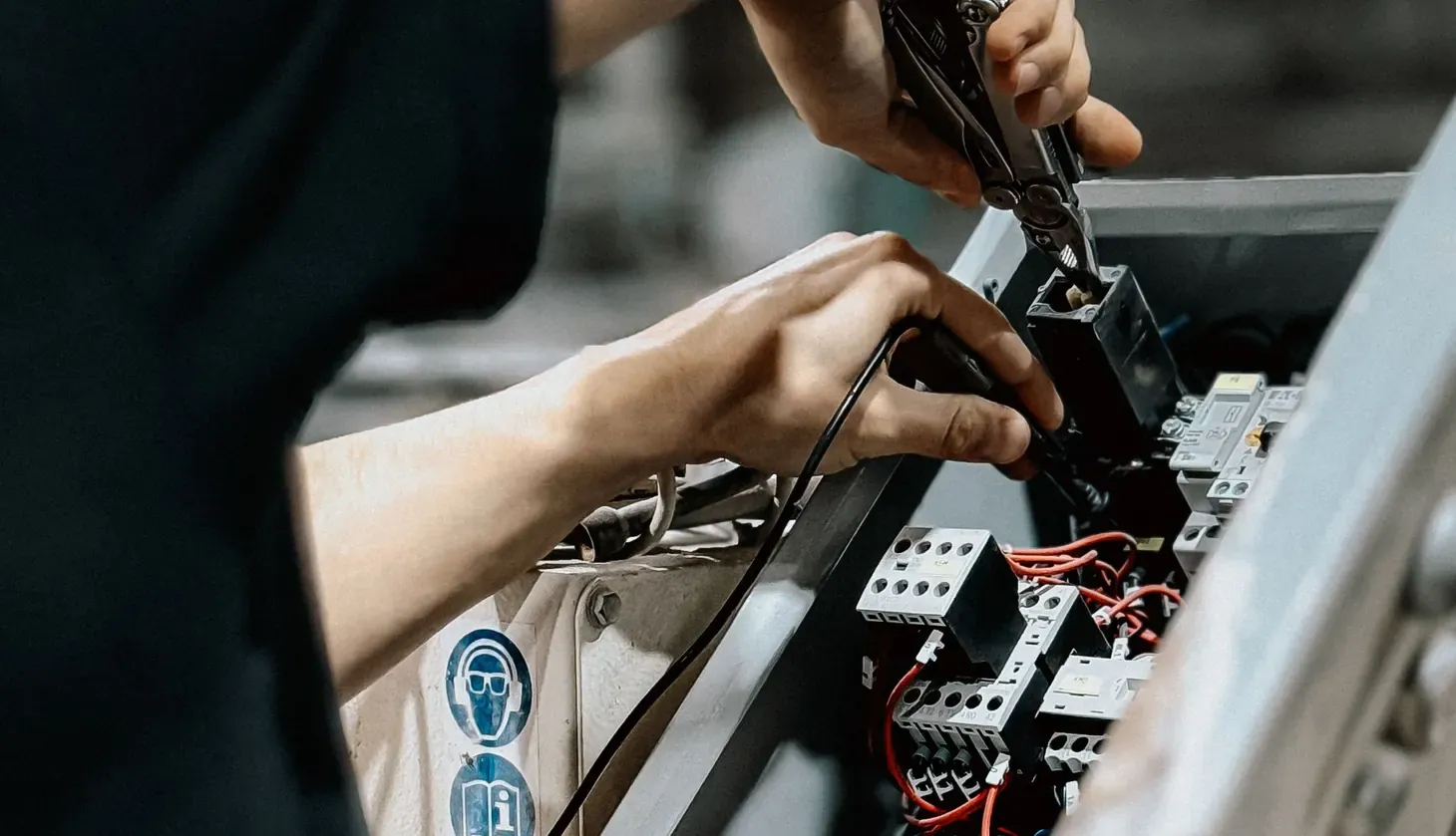 Tecnico che cabla i contattori di un quadro elettrico